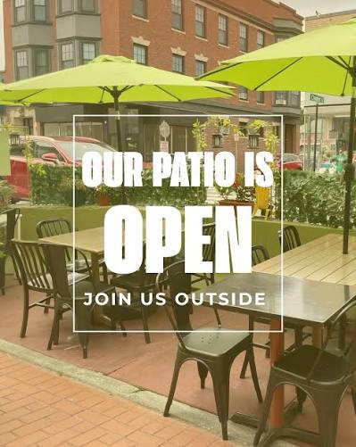 Peppino's Dosa outdoor patio on Moody Street, Waltham — green umbrellas, sidewalk seating